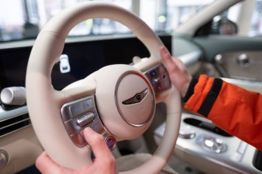 Erkek eller direksiyona, içişlerine, Genesis GV60 Electric Car 'ın kokpitine, Kore markası Hyundai Company, Avrupa' da EV, otomotiv endüstrisinde yenilik, Frankfurt, Almanya - 31 Ocak 2024