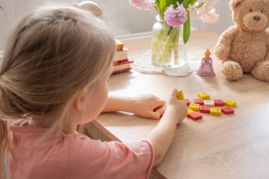 5 yaşında küçük bir çocuğun elinde plastik oyuncaklar, oyun yoluyla duyguları öğrenen çocuk, erken çocuklukta duygusal zeka, çeşitlilik ve dahil olma