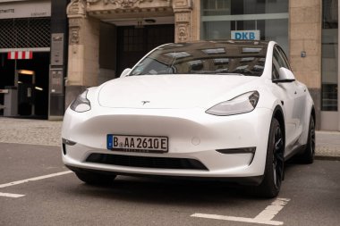 Berlin caddesindeki beyaz model araba, kentsel çevredeki elektrikli araç, sürdürülebilir ulaşım, otomotiv endüstrisindeki son teknolojiler, Berlin, Almanya - 18 Şubat 2024