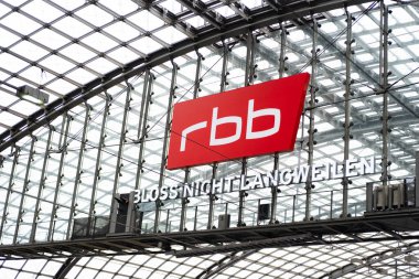 Berlin-Brandenburg radyo haberleri tren istasyonundaki kemerli metal kasa, cam kaplı platform, modern demiryolu altyapısı ve markalı ulaşım merkezleri, Berlin, Almanya - 19 Şubat 2024