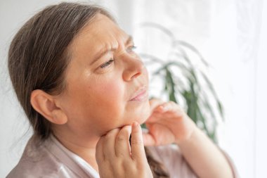 Çift çene, olgun kadın 50 yaşında, insan boynu, yan görüş, cilt kırışıklıkları, yüz gerdirme, yaşla ilgili deri değişiklikleri, estetik enjeksiyon kozmetolojisi, bakım yaşlanmayı önleyici prosedürler.