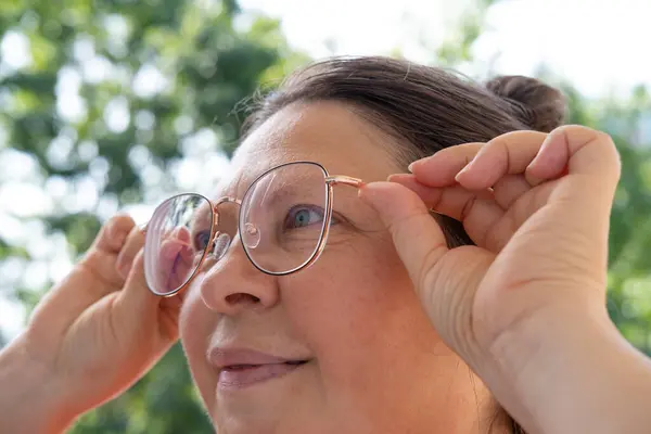 50歳の女性は 老化の結果 視力補正の必要性 視覚的な健康を維持するための定期的な眼科検査などの視力の困難に直面しています — ストック写真
