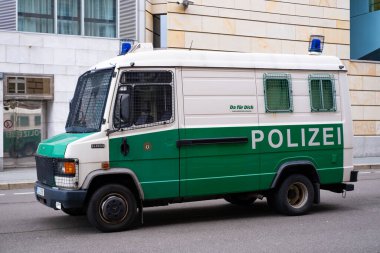 Berlin 'de İngiliz Konsolosluğu yakınlarındaki caddeye park etmiş beyaz ve yeşil polis otobüsü, sembol kanunu ve düzeni, ulusal güvenliğin korunmasında uluslararası işbirliği, Berlin, Almanya - 18 Şubat 2024