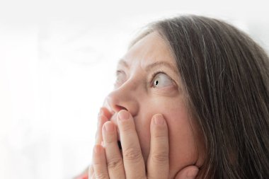 Olgun, gözü pörtlek, gözleri şişmiş, gözleri korkuyla bakan, uyanıkken kâbusa bakan, güçlü bir şaşkınlık ya da şok geçirmiş, korku içinde, evrensel bir korku içinde bir kadın.