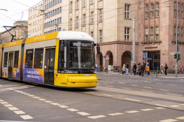 Berlin 'de şehir caddesinden geçen sarı tramvay Flexity Berlin, seyahat, turizm ve şehir molaları, çevre dostu toplu taşıma sistemi, Berlin, Almanya - 18 Şubat 2024