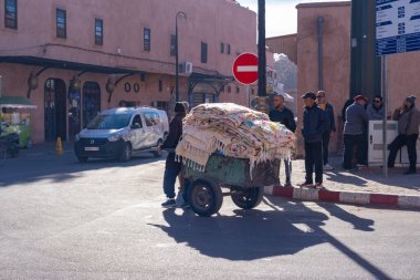 Marakeş halkı şehrin labirent sokaklarında geleneksel el arabası, mal taşımacılığı, sıkı çalışma, Marakeş, Fas - 3 Ocak 2024