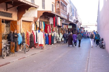 Yerel halk, Marakeş, Fas 'ta 7 Ocak 2024' te labirent sokakları, renkli kıyafetler ve canlı sohbetli resimlerle büyüleyici otantik Afrika kentsel yaşamında geziniyor.