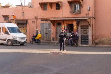 Polis suç soruşturması yapıyor, yerel halkla konuşuyor, Marakeş, Fas 'ta büyüleyici otantik Afrika kentsel hayatı - 7 Ocak 2024
