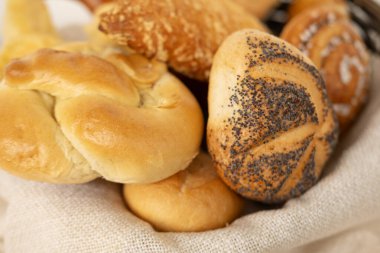 Peynirli çörekler, haşhaşlı çörekler, rulo ekmekler, tuzlu krakerler ve yakın plan tatlı kaymaklı tartlar da dahil olmak üzere ev yapımı lezzetli hamur işleri.