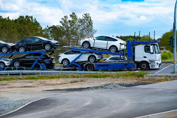 stock image car transporter carrier transports new Tesla vehicles from Gigafactory Berlin-Brandenburg manufacturing plant along highway, Logistics delivery services, Berlin - April 26, 2024