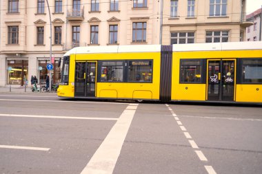 Berlin 'de şehir caddesinden geçen sarı tramvay, seyahat, turizm ve şehir molaları, çevre dostu toplu taşımacılık, sürdürülebilirlik ve çevre, Berlin, Almanya - 18 Şubat 2024