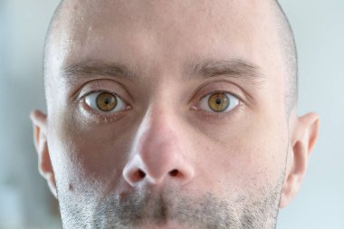 Yarı erkek yüzü, 25-30 yaşlarında genç bir adam, doğrudan insan gözü, konsept izleme, görüş kontrolü, kozmetik prosedürleri