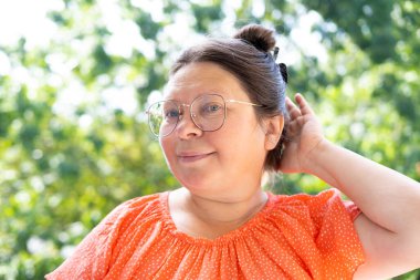 Beyaz, 50 yaşında, çekici bir kadın kameraya bakıyor. Güzel bir yüz, yakından çekilmiş bir portre, cilt kırışıklıkları, yüz gerdirme, yaşla ilgili deri değişiklikleri, estetik enjeksiyon kozmetolojisi.