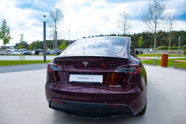 burgundy Tesla model y electric car front Gigafactory Berlin-Brandenburg, Automotive industry in Europe, sustainable and efficient facility yet, Berlin, Germany - April 26, 2024 clipart