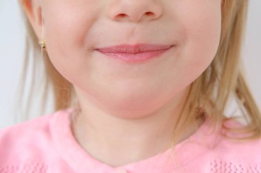 Yüzünün alt kısmını kapat, sarışın kız 3 yaşında neşeli bir gülümseme, duygusal gelişen çocuklar, masumiyeti, saflığı ve güzelliği yakalayan çocuklar.