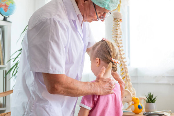 male Orthopedist doctor conducts spinal examination child, young girl shows signs scoliosis, spine deformity, healthcare provider, spine inspection, health check, spinal exam