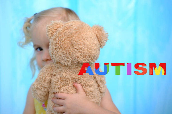 little child with autism, blonde girl 3 years old plays with toy, hugs teddy bear, support for people with autism, self-acceptance and embracing neurodiversity