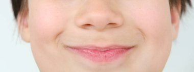 Yüzünün alt kısmını kapat, çocuk. 10 yaşında, dudakları gülümsemeyle sıkışmış, duygusal gelişim kavramına sahip çocuklar.