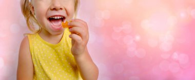 Neşeli küçük çocuk şeker tutuyor, sarışın kız 3 yaşında, jelibonlu tatlı yemek istiyor, sakızlı ayı, çocuk iştahlı, mutlu çocukluk, dengeli diyet, tatlı hayat, sağlıksız yemek, helal yemek