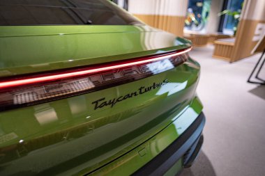 Yeni yeşil Porsche Taycan Turbo S pilli spor araba, Sedan Porsche Otomobil Holding galeri vitrininde, otomotiv endüstrisinde yenilik Berlin 'de, Almanya' da 17 Şubat 2024