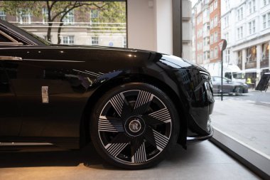wheel of British black luxury limousine Rolls-Royce Phantom VIII with logo, wheel, advertising sign, manufactured Rolls-Royce Motor Cars automobile manufacturer auto salon, London - May 22, 2024 clipart