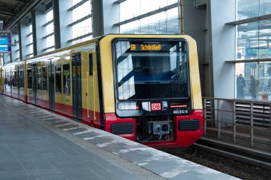 Deutsche Bahn bölgesel treni Berlin istasyonuna ulaşır. Platformda bekleyen yolcular, toplu taşıma gecikmesi, günlük ulaşım, Berlin - 25 Nisan 2024