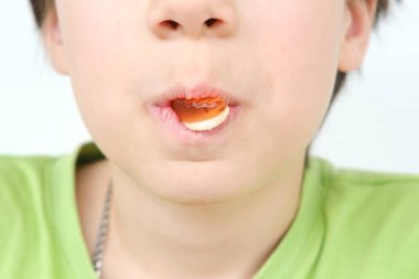 Çocuk, ağzında tutuyor ve jelibon, jelibon, çocuk lezzeti, sağlıklı ve sağlıksız yiyecekler, helal yiyecekler yiyor.