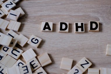 Dikkat eksikliği hiperaktivite bozukluğu, tahta alfabe blokları, harflerden hiperaktiflik kelimesi, çocuk desteği ve duyguları yönetmek için anlayış gerektirir.
