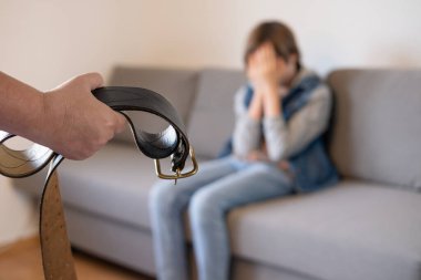 Deri kemerli bir kadın kanepedeki ergen çocukla, otoriter ebeveyn disiplini ve cezasıyla, aile içi çatışmalarla ve kuşak farklılıklarıyla yüzleşiyor.