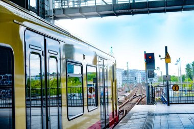 Deutsche Bahn bölgesel treni Berlin istasyonuna ulaşır. Platformda bekleyen yolcular, toplu taşıma gecikmesi, günlük ulaşım, Berlin - 25 Nisan 2024