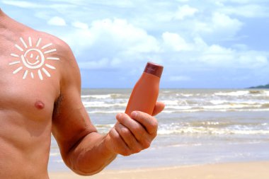 Kahverengi krem, bronzlaşmış erkek elinde losyon şişesi, arka planda deniz dalgaları, plajda kozmetik tüplü yaz güneşi koruma şablonu, ürün sunumu, paket reklamı