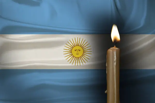 stock image mourning candle burning front of flag Argentina, memory of heroes served country, grief over loss, national unity in challenging times, state's history