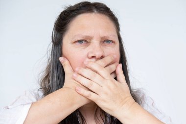 Olgun bir kadın elleri ile ağzını kapatır, sır saklamaya ve kendini disipline etmeye çalışır, sözlerine dikkat et, güç sessizliği, dedikodulara karşı ihtiyatlı ol.