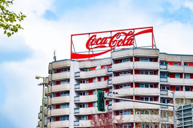 ikonik Coca-Cola logosu yüksek binaların tepesinde içecek markasının küresel erişimini sergiliyor, ferahlatıcı ve keyifli, Berlin, Almanya - 24 Nisan 2024
