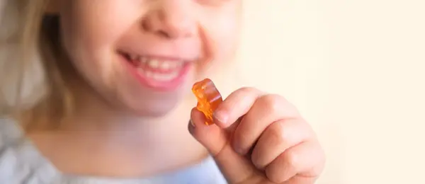 stock image small child, blonde girl 3 years old wants to eat gelatinous sweets, gummy bear, kid has a good appetite, happy childhood, balanced diet, sweet life, unhealthy food, halal food