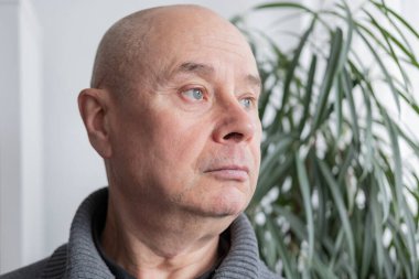 Ciddi yüzlü, düşünceli, mesafeyi seyreden, hayatın zorluklarını düşünen, hayatın sıkıntılarının yükünü taşıyan, çatık kaşlı yaşlı adam.