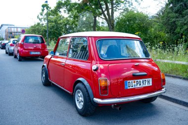 Zamansız Retro kırmızısı Mini Cooper eski zamanlayıcı modern sokağa park etmiş, zamansız nostalji tasarımı, otomotiv tutkusu, tarih otomotiv endüstrisi, Darmstadt, Almanya 'da otomotiv ikonu - 26 Haziran 2024