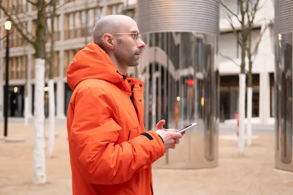 stock image Close-up modern mobile phone in male hands against backdrop of winter streets of Berlin, Technology and urban life, Modern communication, Digital Nomadism, device usage