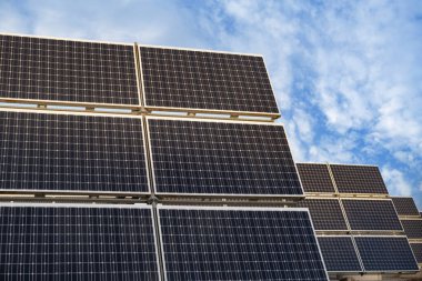 Sıralar halinde fotovoltaik paneller güneş çiftliği boyunca uzanıyor, sürdürülebilir gelecek için güneşin enerjisini yakalıyor, güneş çiftlikleri temiz enerji üretiyor, güneş ışınlarından elektrik üretiyor.