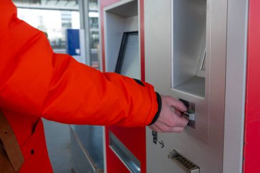 Gezgin, terminalden bilet alıyor, tren biletini onaylıyor, toplu taşıma, erkek yolcu, seyahat verimliliği, bilet makinesi, modern ulaşım sistemleri, Berlin, Almanya - 24 Nisan 2024