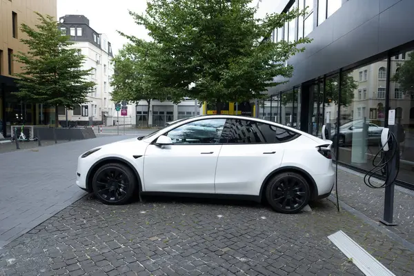 stock image white Tesla Model y car charging on street, innovative electric car Tesla Motors, trend EV in contemporary Europe, sustainable transportation, Automotive industry, Frankfurt, Germany - June 28, 2024