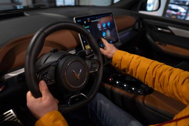 Erkek elleri direksiyonda, iç mekanda, Vinfast vf 8 'in pilot kabininde elektrik geçişi, Vietnam otomotiv endüstrisinde gelişmiş teknolojiler, test sürüşleri, Berlin, Almanya - 17 Şubat 2024