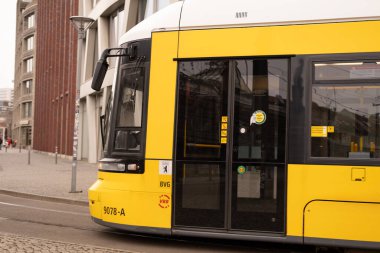 Berlin 'de şehir sokağından geçen sarı tramvay Flexity Berlin, seyahat, turizm ve şehir molaları, Everyday City hayatı, çevre dostu toplu taşıma sistemi, Berlin, Almanya - 18 Şubat 2024