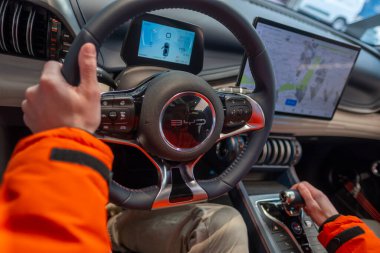 Erkek eller direksiyonda, iç mekanda, BYD ATTO 3 Car in Studio 'nun kokpiti, test sürüşü, elektrikli araç Çinli BYD üreticisi, otomotiv endüstrisi, Frankfurt, Almanya - 31 Ocak 2024