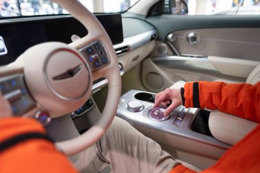 Genesis GV60 Electric Car kullanan adam, düğme düğmeleri, joystickler, SUV Kore markası Hyundai şirketi, dahili ekipman, sürücü güvenliği, Frankfurt, Almanya - 31 Ocak 2024