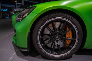 Çarkıfelek yeşili Porsche Taycan Turbo S pilli spor araba, farlar, sedan Porsche Otomobil Holding sergi salonunda, otomotiv endüstrisindeki icatlar Berlin, Almanya 'da - 17 Şubat 2024