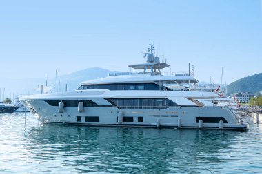 Işıldayan beyaz lüks özel yapım yat, marinaya yanaşmış motor, lüks sahil tatili, deniz deneyimi, özel yolculuk bekleyen yolcular, Tivat, Karadağ - 5 Ağustos 2024