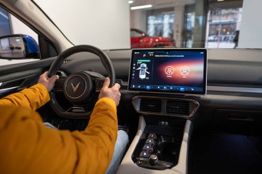 male hands on steering wheel, Interior, cockpit of Vinfast vf 8 electric crossover, advanced technologies in vietnamese automotive industry, test drives, Berlin, Germany - February 17, 2024 clipart