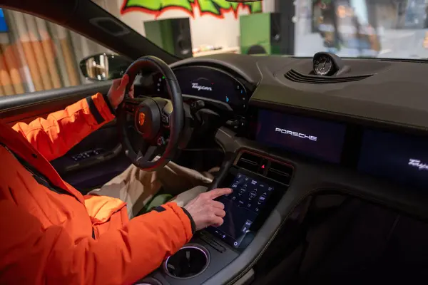 stock image steering wheel, Interior, cockpit modern EV, man in car driving Porsche Taycan Turbo S electric sports Car, driving safety, Innovation in automotive industry, Berlin, Germany - February 17, 2024