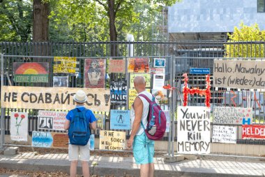 Baba ve oğul, Rusya Büyükelçiliği 'nin Viyana' nın ön tarafındaki Alexei Navalny anıtının önünde Putin, Viyana - 1 Ağustos 2024 tarihlerinde öldürülen Rus muhalefet siyasetçisinden alıntılar yaparak çit fotoğraflarında durdular.